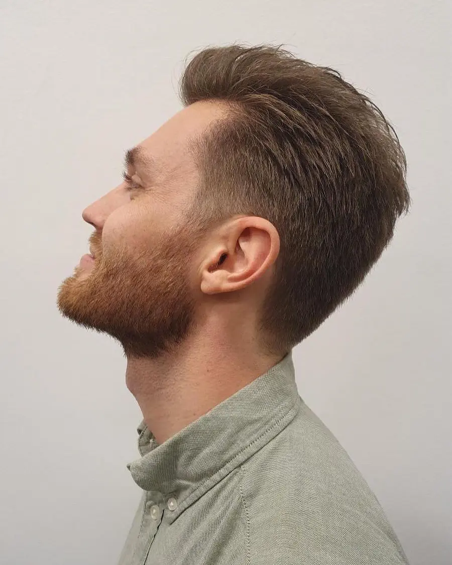 Man i profil med en modern, strukturerad herrklippning och välansat skägg. Utfört hos herrfrisör i Göteborg.